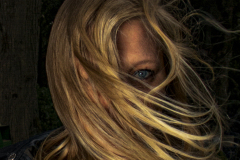 Unveiled, Fine art portrait of a blonde woman with windblown hair revealing one striking blue eye.