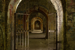 Passage Fine art photograph of repeating stone arches leading into darkness, creating a timeless composition of light, shadow and perspective.