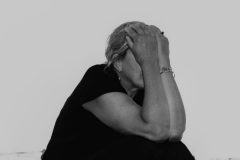 Black and white fine art photograph of a woman in water exploring stillness, form, and quiet human presence.