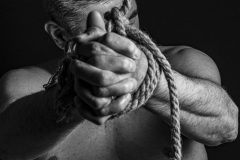 Black and white portrait of a man with a weathered expression, emphasizing character, emotion, and fine art photography style.