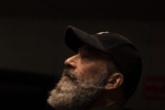 “Fine art portrait of man in a minimal setting, focusing on stillness, light, and presence.”