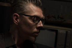 Musician playing harmonica in dramatic low-key portrait by Peter Meirmans
