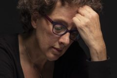 “Fine art portrait of strong woman in a minimal setting, focusing on stillness, light, and presence.”