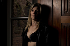 Silent Strength, Fine art portrait of a woman standing in dramatic window light inside a historic monastery, expressing quiet strength and emotion.